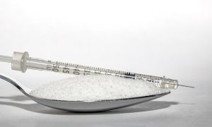 An image of a spoon with sugar on it to talk about the long term effects of too much sugar.