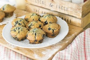 A picture of some blueberry muffins on a white plate with 