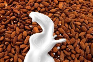 An image of milk being poured into almonds to discuss types of plant-based milks and their benefits.