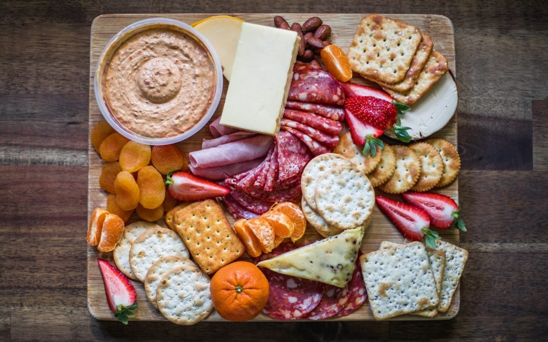 A plate of cheese, meat, crackers and hummus to discuss clean snacks