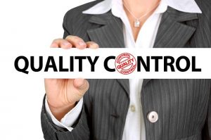 An image of a woman holding text saying "quality control," to represent how the AMA created a monopoly out of health care trying to make alternative treatments seem like quackery.