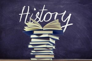 An image of a chalkboard with the word "History" on it and a stack of books to discuss what my next blog will cover on the history of healthcare.