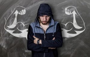 An image of a man who looks fearful with an image of strong muscles behind him to symbolize fear vs. building up a strong immune system.