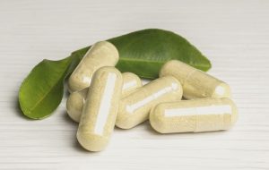 An image of some supplements with leaves behind them to talk about supplements that help when the immune system is weak.