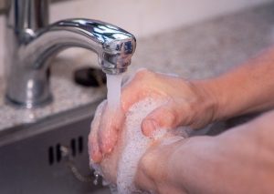 An image of washing hands underneath a faucet to discuss applying the Cellular Terrain Theory to your life.
