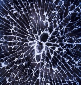 An image of glass breaking to symbolize breaking the distorted views of how health works.