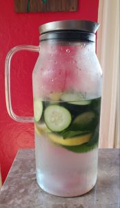 An image of a cold pitcher with lemon, cucumber, and mint to talk about how you can infuse water to make it more interesting.