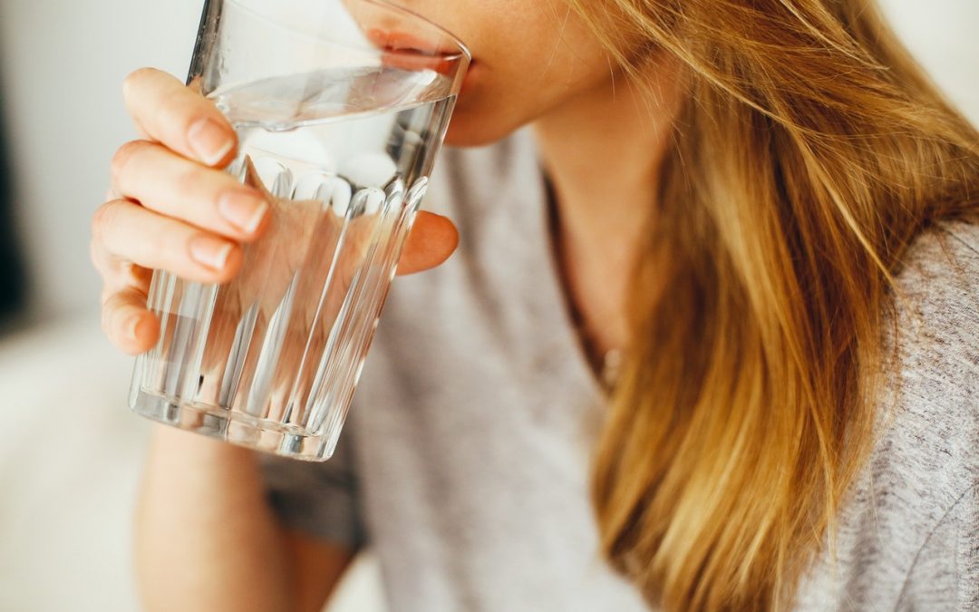 An image of a person drinking water to discuss how to increase water intake and drink clean water.