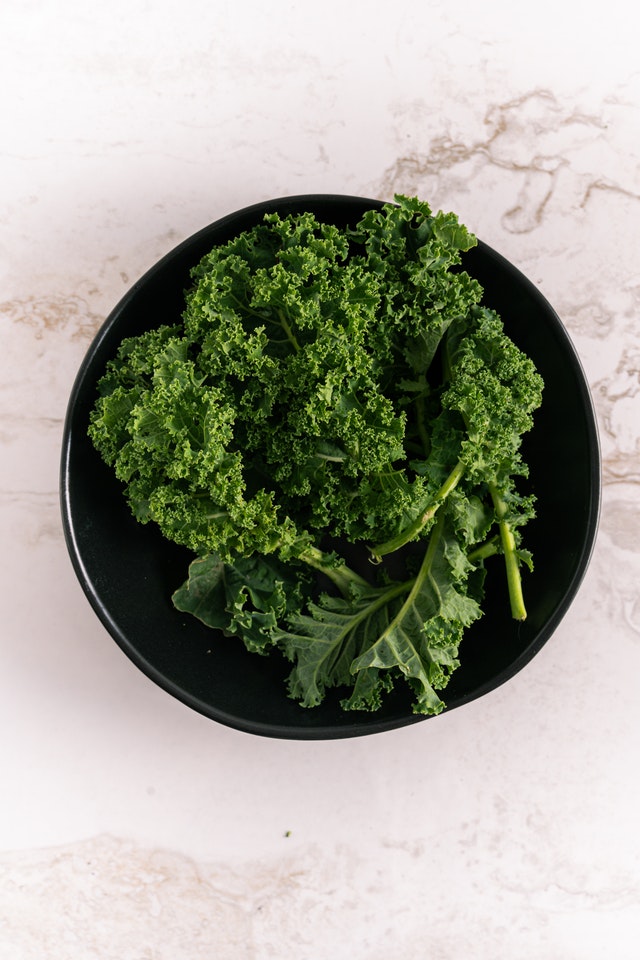 An image of kale in a bowl to talk about its benefits as a superfood and the essential vitamins and minerals in contains.