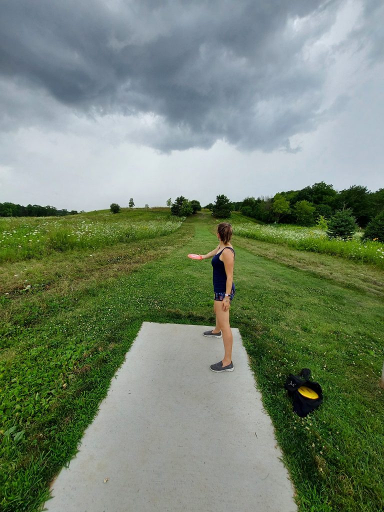 An image of me throwing a frisbee golf disc with gray clouds emerging to discuss tips on how to get the full benefits out of nature.