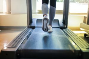 An image of a girl walking on a treadmill to talk about why I love HIIT training