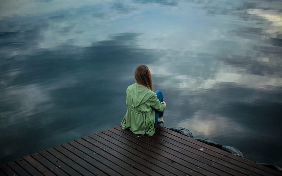 An image of a woman staring at the water to talk about how to manage stress with a stress relief kit.