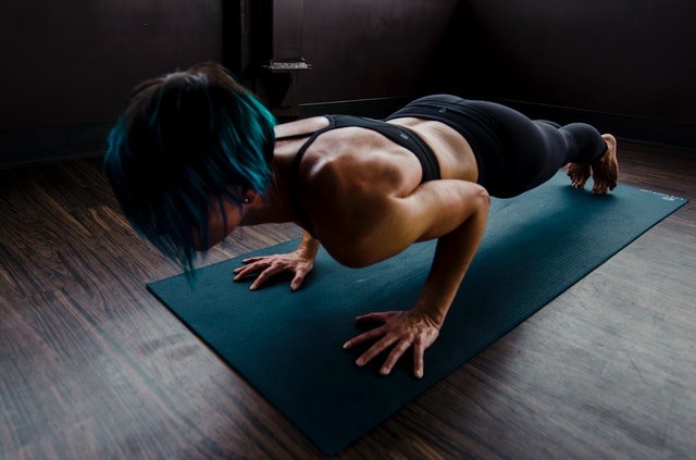 A woman doing a plank exercise to talk about how exercise is essential for living a wellness lifestyle.