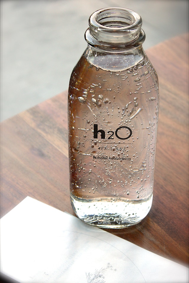 An image of a glass of H2O to talk about how drinking water is essential to living a wellness lifestyle.