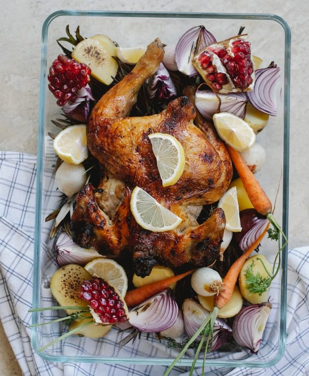 An image of a whole chicken surrounded by vegetables to talk about how to eat whole foods.
