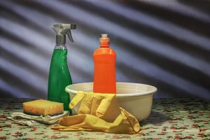 An image of chemical cleaners, a sponge, and gloves to talk about who regulates chemical cleaning products.