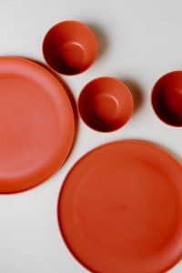 Zdjęcie czerwonych plastikowych talerzy i misek, które opowiadają o niebezpiecznych toksynach w plastiku.