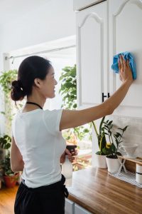 An image of someone cleaning with homemade cleaners to talk about the importance of avoiding chemical cleaners.