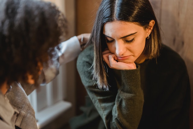 An image of a person struggling and another person comforting them to talk about how empathy in communication is needed for stronger relationships.
