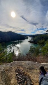 An image of my my feet as I'm sitting on a mountain looking down at the water to talk about how being grateful has had an impact on my life.