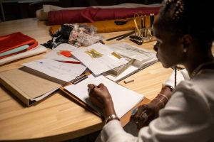 An image of a person working with piles of documents and other paperwork on her desk to talk about how clutter is distracting. 