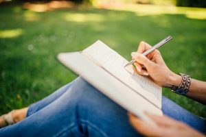 An image of a girl journaling to talk about how to journal as a self-esteem boosting activity.