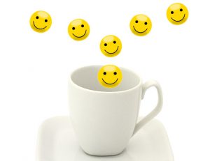 An image of smiley faces being poured into a cup to talk about creating happiness every day. 