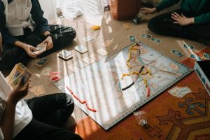 An image of some people playing board games to talk about how playing games with friends or family can be a fun and happy activity. 