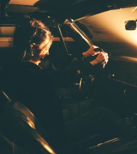 An image of a woman screaming while driving her car to talk about how you need to feel anger fully. 